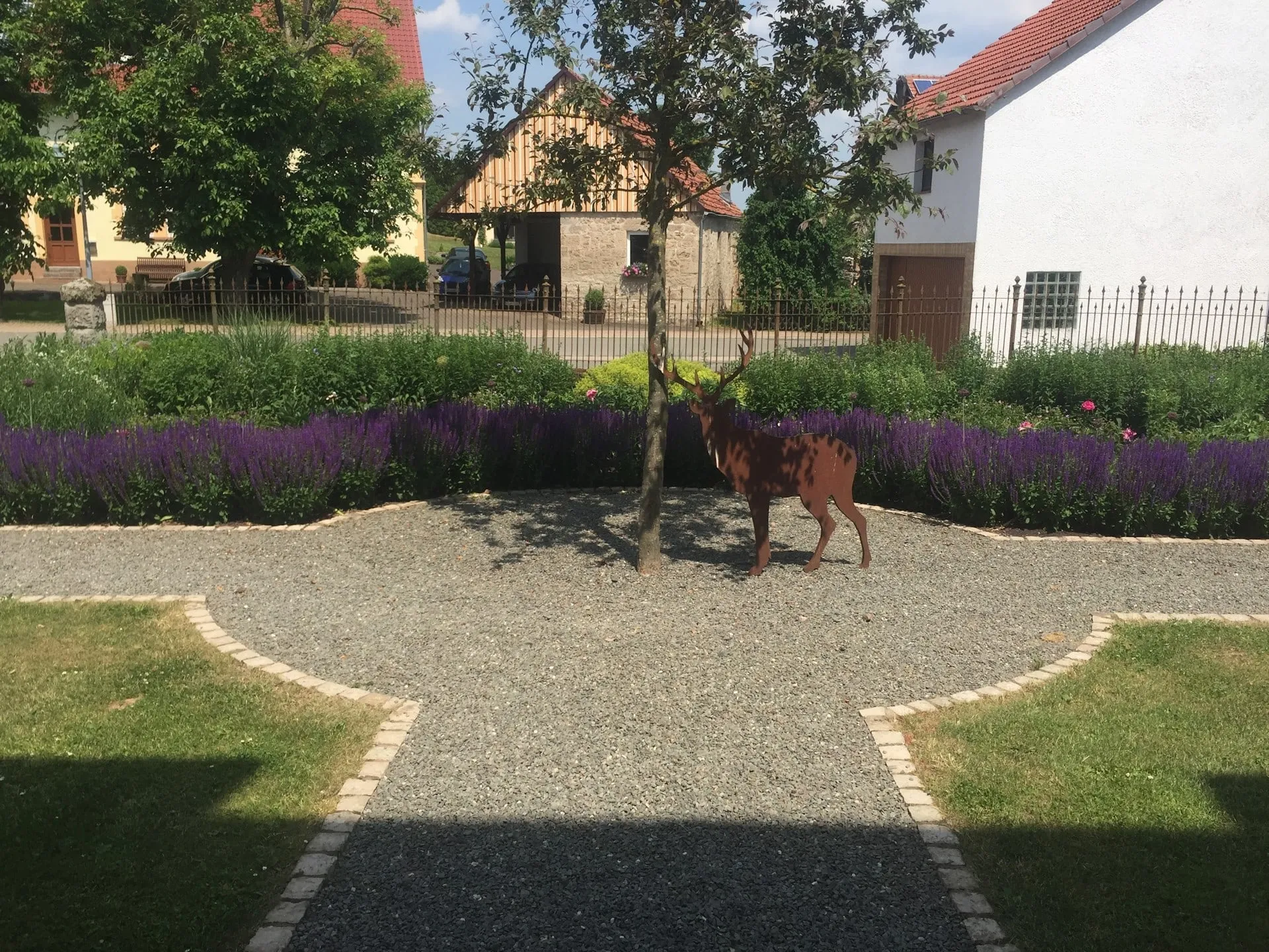 Kiesweg mit Staudenpflanzung. Ästhetische Verbindung von Wegführung und Staudenbeet